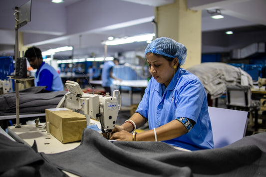 Woman operates sewing machine in a textile factory.