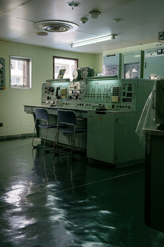 Control room with vintage equipment and chairs.